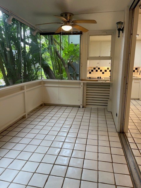 A room with a ceiling fan and tiled flooring.